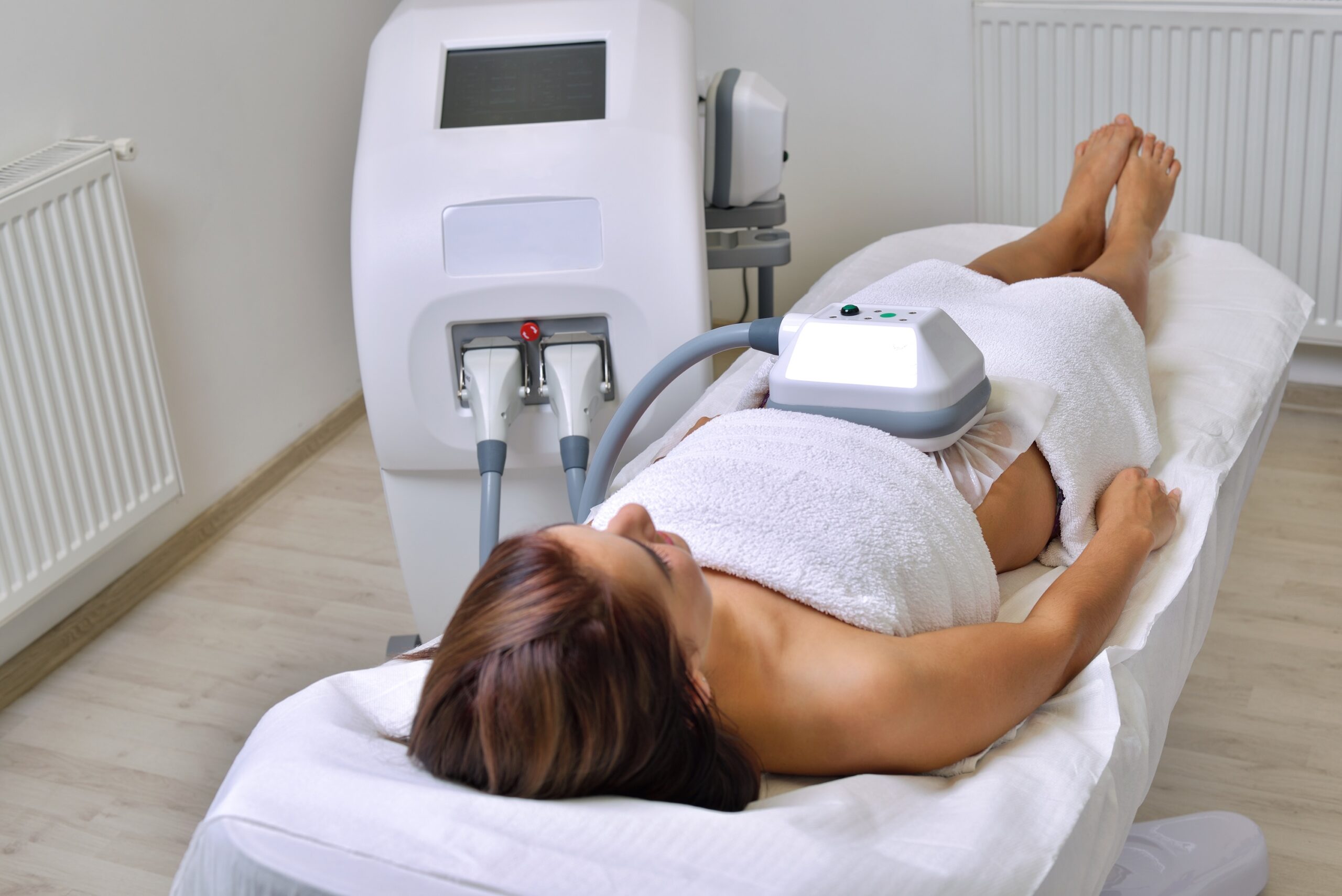 Beautiful young woman getting cryolipolyse treatment in cosmetic cabinet Beautiful young woman getting cryolipolyse treatment in cosmetic cabinet